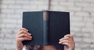 Person holding a book in front of their face