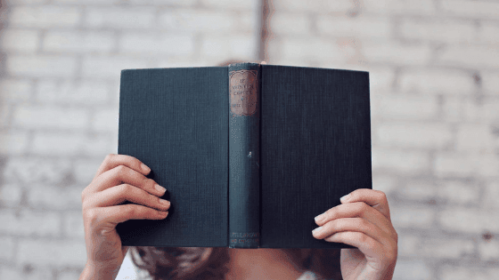 Person holding a book in front of their face