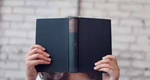 Person holding a book in front of their face